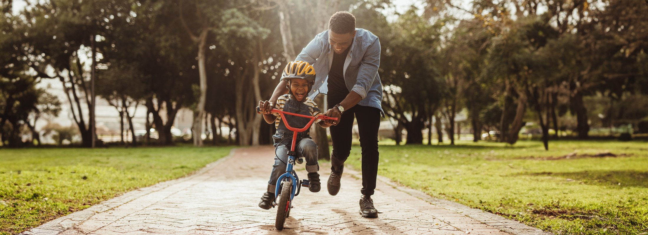 father teaching his son cycling at park