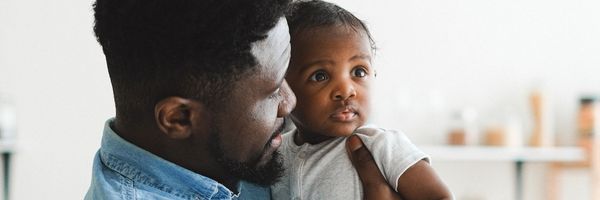 a black man is holding his young daughter