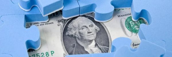A close-up of a U.S. one-dollar bill partially covered by blue puzzle pieces, forming a frame around George Washington's portrait. From Lawrence Law Firm New Jersey Family Lawyer.