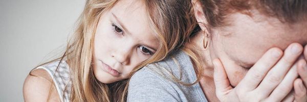 A young girl leans sadly on the shoulder of a woman who has her face in her hand, suggesting emotional distress. From Lawrence Law Firm New Jersey Family Lawyer.